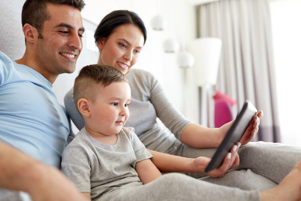 familia feliz con la tableta PC en la cama en casa
 - Foto, Imagen