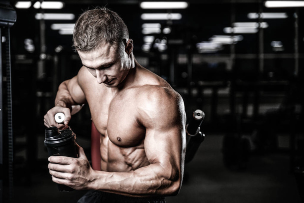 Muscular Man Resting After Exercise And Drinking From Shaker - Photo, image