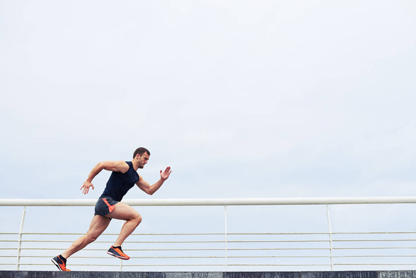 Athlete running outdoors - Foto, afbeelding
