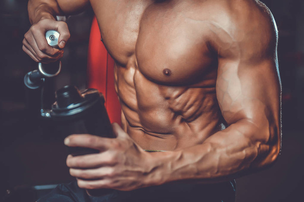 Muscular Man Resting After Exercise And Drinking From Shaker - Foto, Imagen