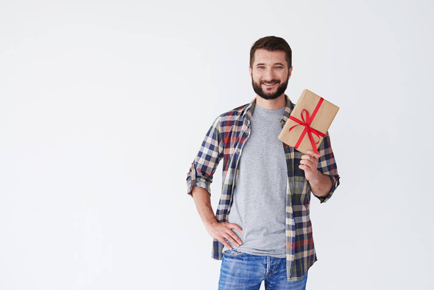 Усміхнений випадковий чоловік тримає подарункову коробку в руках
 - Фото, зображення