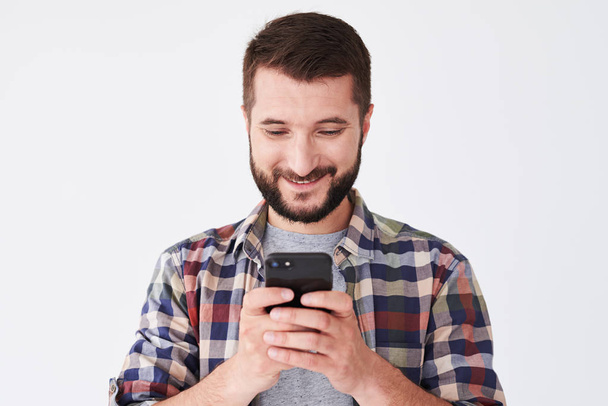 Smiling man using smartphone, close-up shot  - Foto, afbeelding