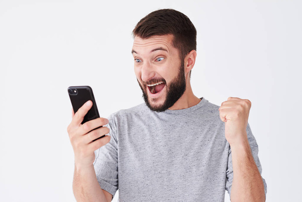 Podekscytowany mężczyzna młody krzyczy na jego telefon komórkowy - Zdjęcie, obraz