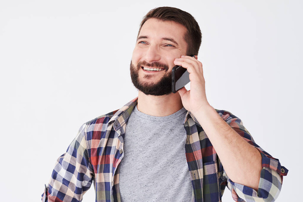 Portrét veselý vousatý muž stojí a mluví na mobil  - Fotografie, Obrázek