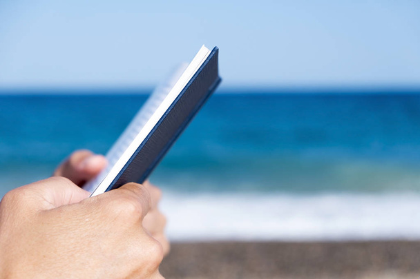 Homme lisant un livre sur la plage
 - Photo, image
