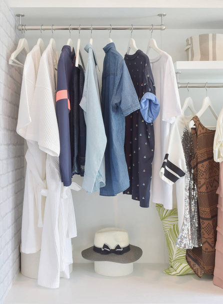 Panos casuais pendurados em guarda-roupa aberto em casa moderna
 - Foto, Imagem