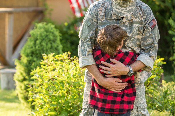 Felice riunione di soldato con la famiglia all'aperto in una giornata di sole
 - Foto, immagini