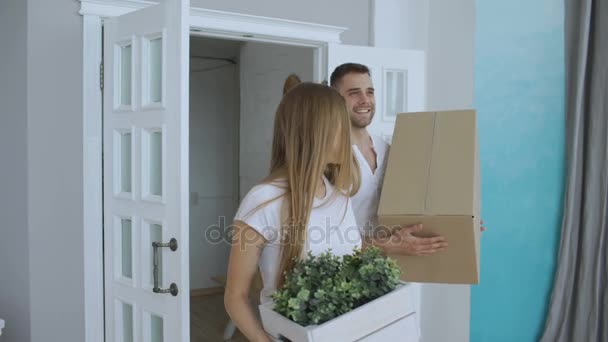 Young happy couple first time walking in new house after moving and kiss each other - Footage, Video