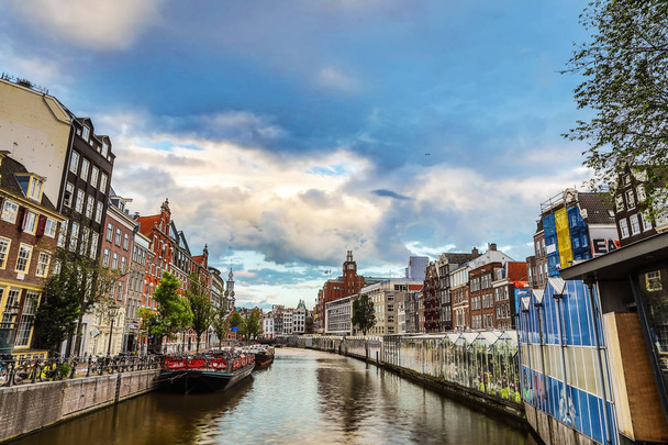 Os canais e aterros mais famosos da cidade de Amsterdã durante o pôr do sol. Vista geral da paisagem urbana e da arquitectura tradicional neerlandesa
. - Foto, Imagem