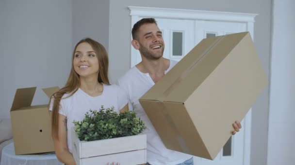Happy couple watching their new home excited. Young man give keys to his girlfriend and kissing her - Séquence, vidéo