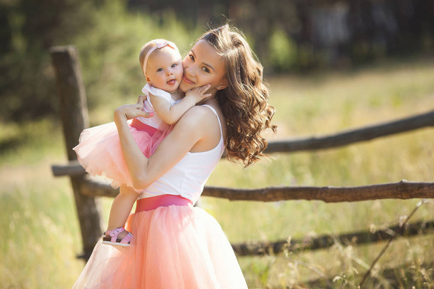 Young pretty mother with her little baby outdoors. Beautiful wom - Photo, Image