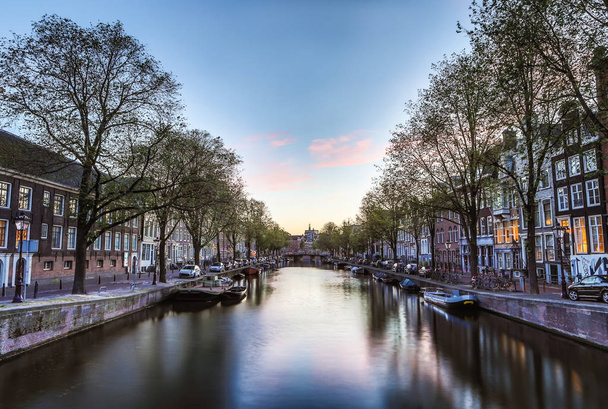 Les canaux et remblais les plus célèbres de la ville d'Amsterdam pendant le coucher du soleil. Vue générale du paysage urbain et de l'architecture traditionnelle néerlandaise
. - Photo, image