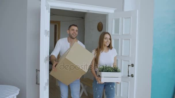 Joven feliz pareja caminando en nueva casa después de la reubicación y besarse
 - Imágenes, Vídeo