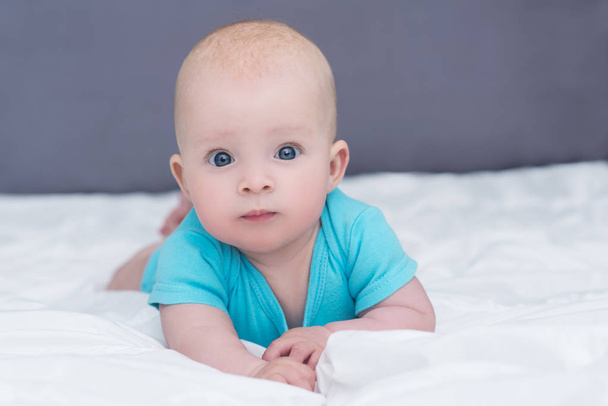 adorable baby girl or boy in blue shirt with big blue eyes, indo - Photo, image
