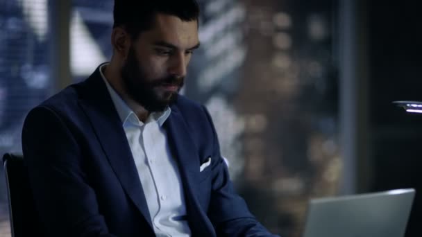 Late at Night Businessman Works on a Laptop in His Private Office with Big City Window View. - Materiał filmowy, wideo