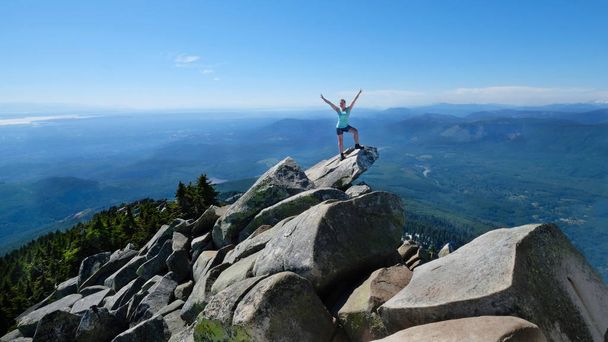 Mujer feliz en pose exitosa en la cima de la montaña con vistas panorámicas
.  - Foto, imagen