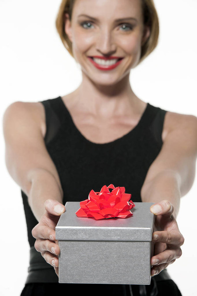 Happy young woman giving a gift - Foto, Imagen