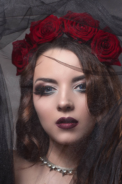 όμορφη νεαρή γυναίκα με τριαντάφυλλα λουλούδι στα μαλλιά. ομορφιά κορίτσι με μακιγιάζ σε σκούρο φόντο. σκούρο κόκκινο lips.close-up μόδας retouched πορτρέτο - Φωτογραφία, εικόνα
