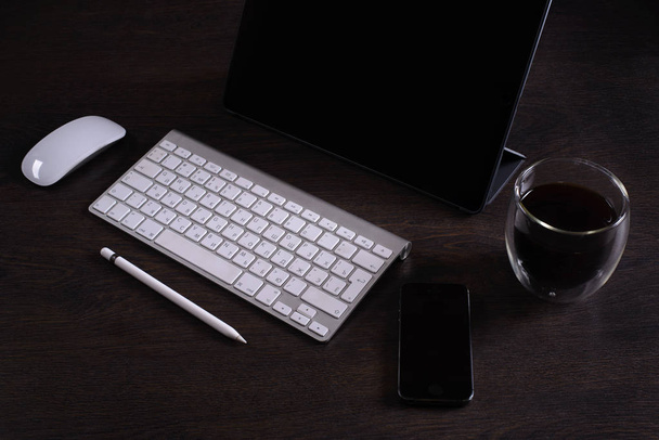 The layout of the freelancer Desk accessories and tool, digital tablet, keyboard,stylus pen,coffee Cup, telephone, business person, working place - Photo, Image