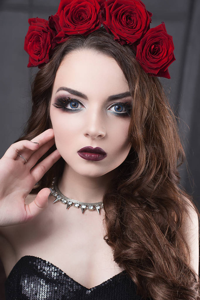 krásná mladá žena s růží květinou ve vlasech. krásy dívka s make-up tmavém pozadí. tmavě červené lips.close-up módní retušované portrét - Fotografie, Obrázek