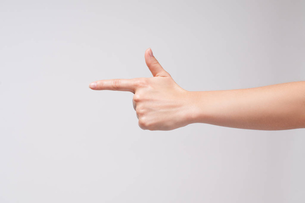 Female hand points a finger at something on white background.  - Φωτογραφία, εικόνα