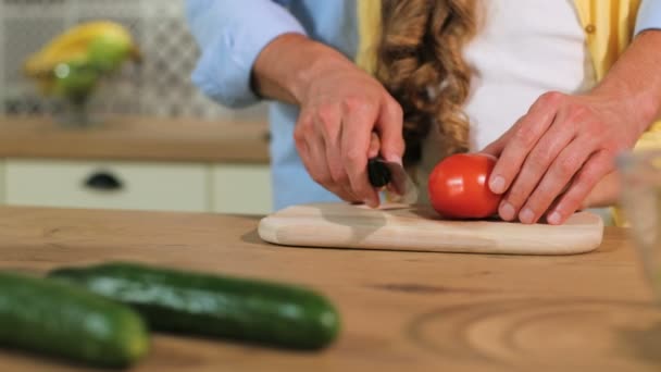 Close up shot of father hands cutting the tomato, daughter help cutting the ingredients. - Video, Çekim