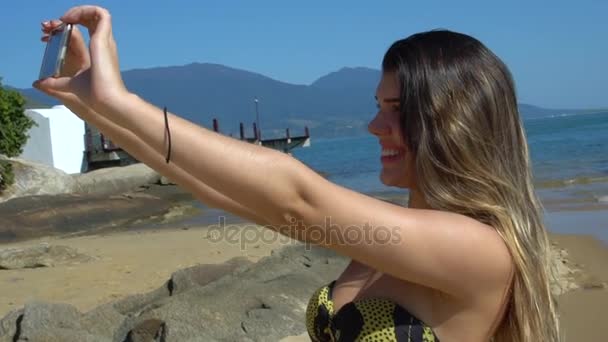 Νεαρή γυναίκα λήψη Selfie σε μια παραλία - Πλάνα, βίντεο