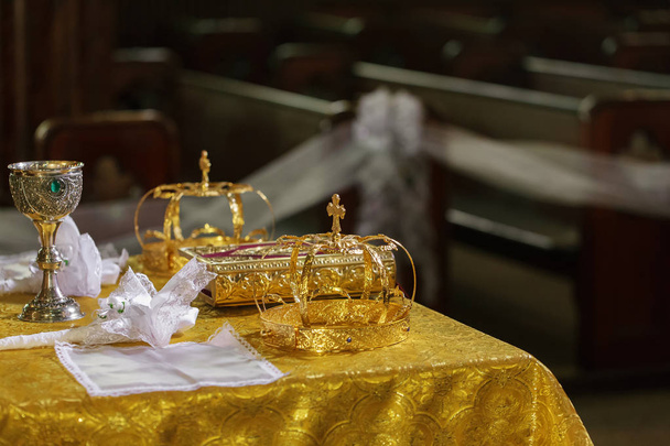 Az esküvő, az asztalon az egyház arany koronát. - Fotó, kép