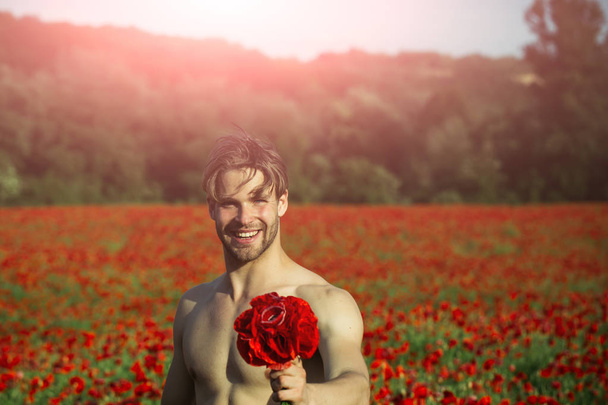 bouquet at happy man in field of red poppy - Foto, afbeelding