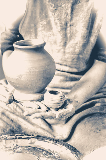 Potter holds made pots. Old vintage style. - Zdjęcie, obraz