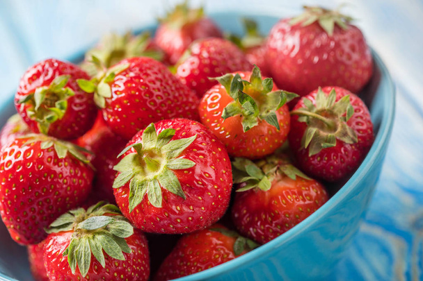 Ripe red strawberries in white bowl. - Fotó, kép