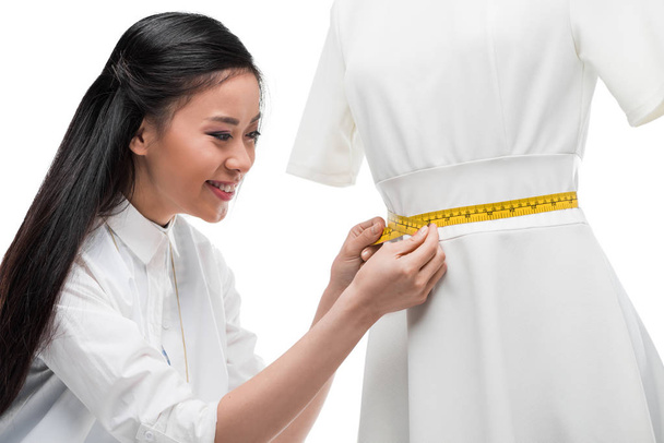 アジアのドレス メーカーがダミーにドレスを測定 - 写真・画像