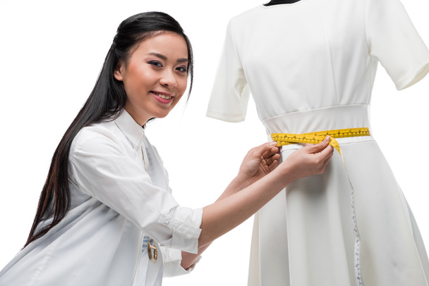 fashion designer measuring dress on dummy - Foto, imagen