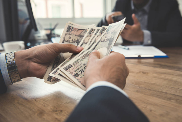 Бизнесмен считает деньги, японские иены
 - Фото, изображение