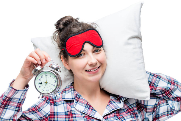 Μια γυναίκα με ένα ρολόι συναγερμών και ένα μαξιλάρι το βράδυ πριν g - Φωτογραφία, εικόνα