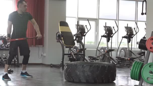 Чоловіча фітнес-модель тренування тренування відьма важка і велика шина і молоток у фітнес-центрі
 - Кадри, відео