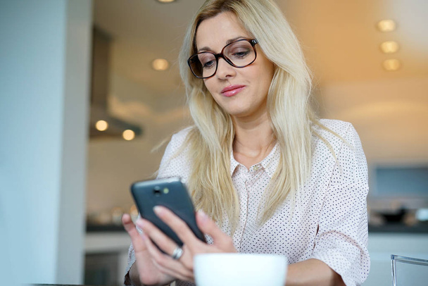 woman in office using smartphone - Photo, image
