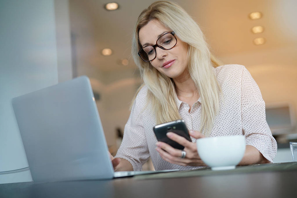 woman in office using smartphone - Photo, image