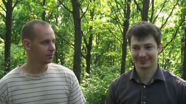 deux jeunes hommes traversent les bois et parlent - Séquence, vidéo