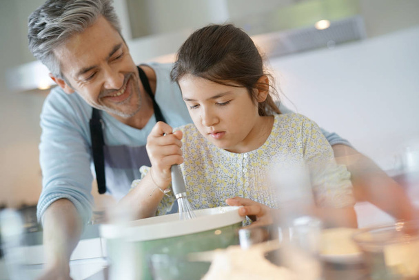 Daddy with daughter baking cake - Foto, afbeelding