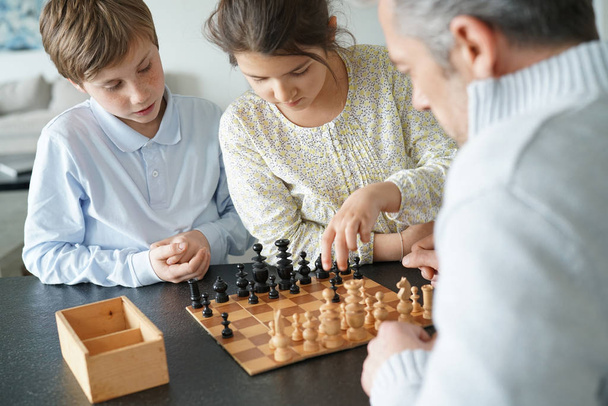 Family playing chess game  - Фото, изображение