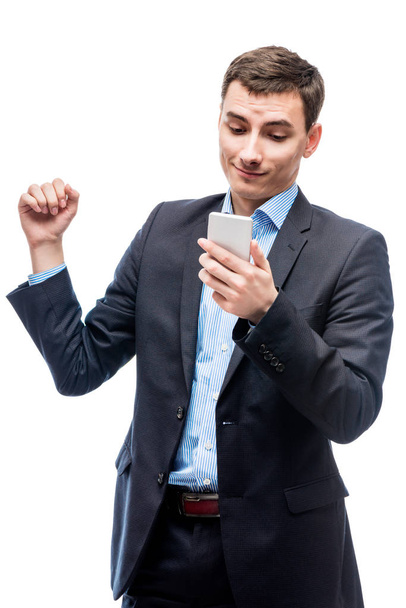 Joyful successful businessman with a phone in hands on a white b - Fotoğraf, Görsel