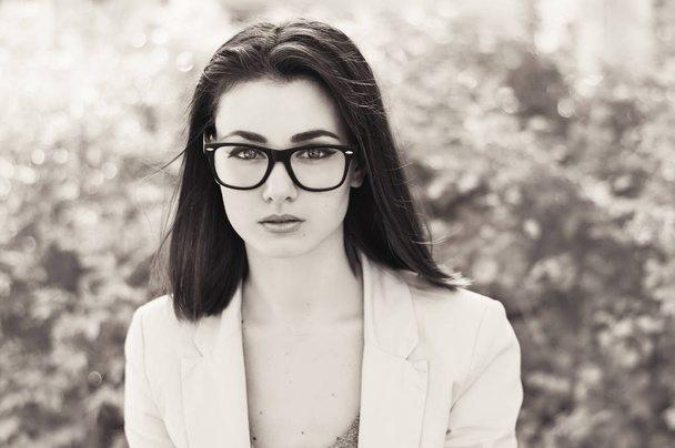 Portret van jonge Europese zakenvrouw met bril, bob kapsel en witte jas - Foto, afbeelding
