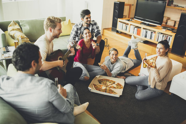 Young people eating pizza and drinking cider - Photo, Image