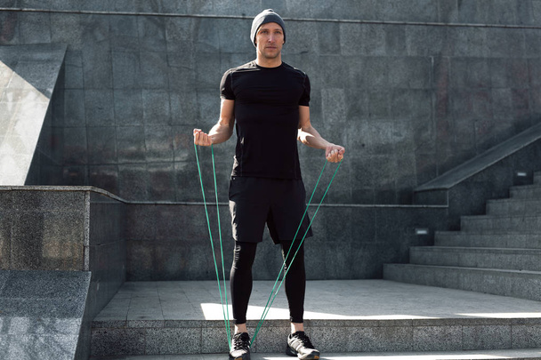 Man warming up with jumping rope - Foto, imagen