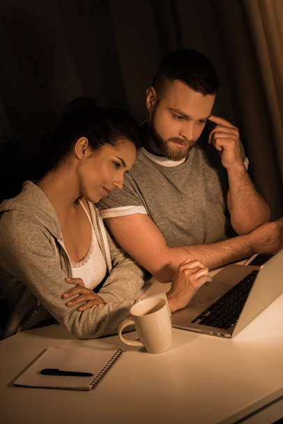 pensive couple looking at laptop at home - 写真・画像