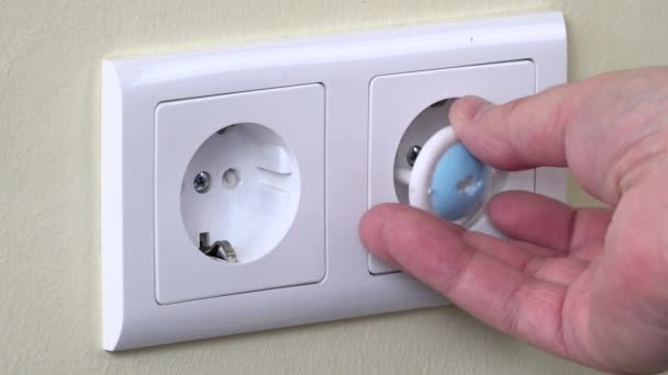 Ręce należy zainstalować zatyczki bezpieczeństwa w gniazdka energii elektrycznej na ścianie - Materiał filmowy, wideo