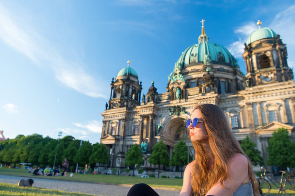 Pretty gil sitting in front of Berlin Cathedral wearing sunglusses - Photo, image