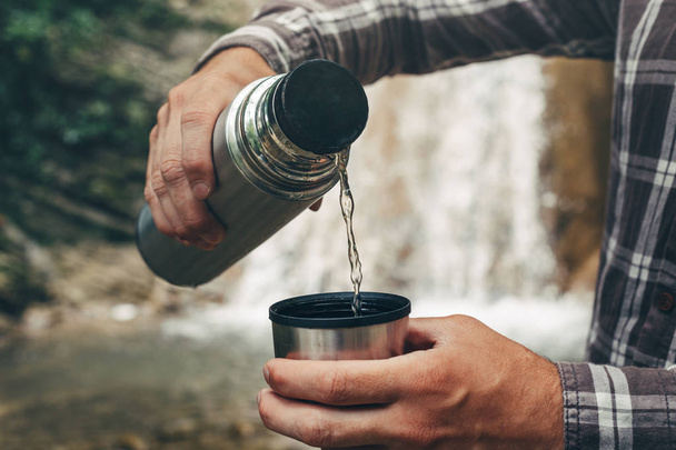 Unrecognizable Traveler Pouring Tea Or Coffee To Cup From Thermos - Foto, Bild