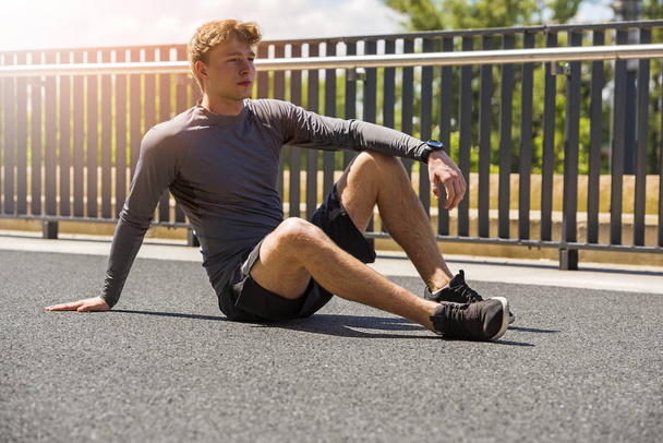 Exhausted man resting after jogging in full sun - Photo, Image